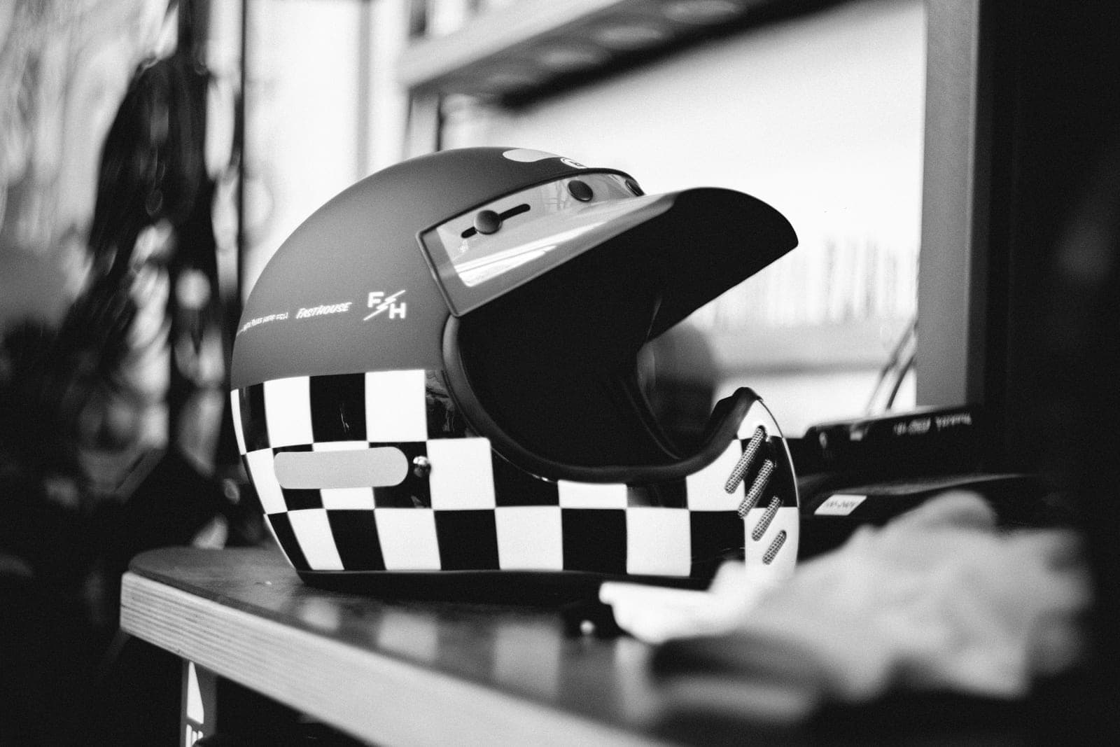 A row of motorcycle helmets on a workshop shelf