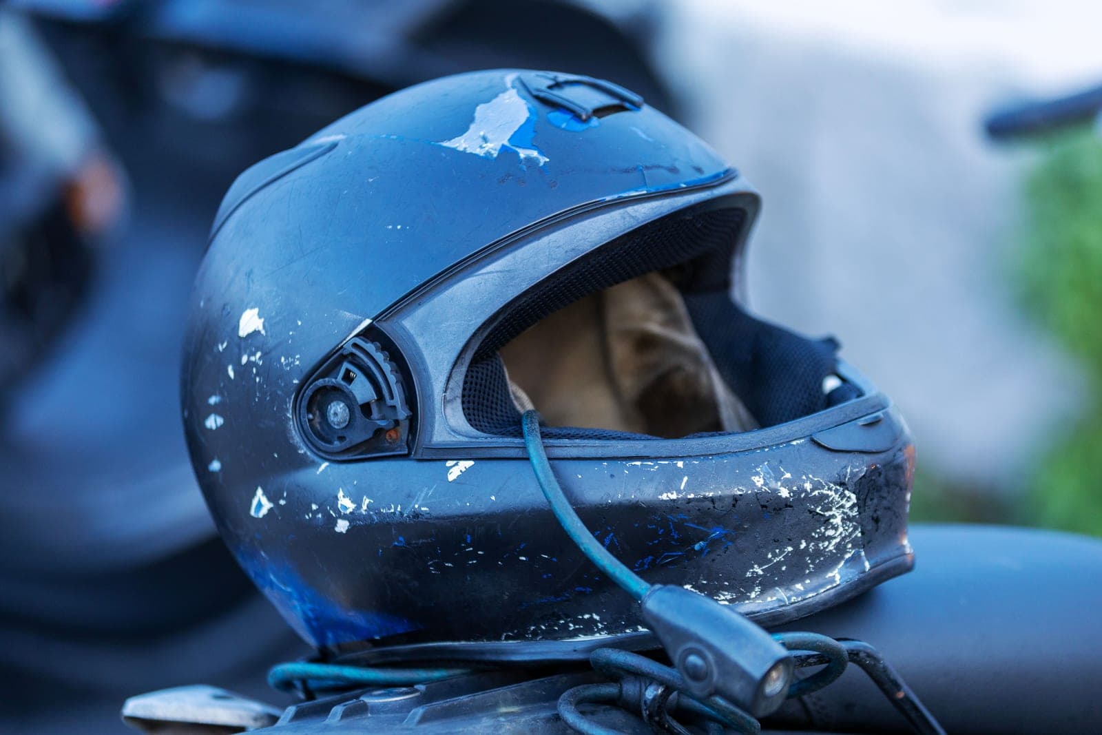 A well-used motorcycle helmet resting on a garage bench